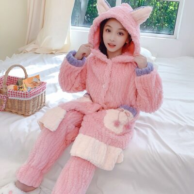 Peignoir enfant chaud et mignon, fille ou garçon en rose, porté par une petite fille brune qui est assise sur un lit.