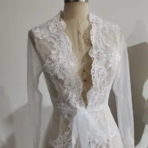 Dans un atelier de couture, on voit une peignoir tout en dentelle blanche, très sophistiqué et élégant !