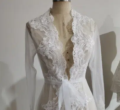 Dans un atelier de couture, on voit une peignoir tout en dentelle blanche, très sophistiqué et élégant !