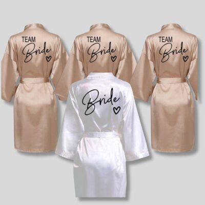 Peignoir de mariage en satin pour femme en version beige et blanche, sur fond gris.