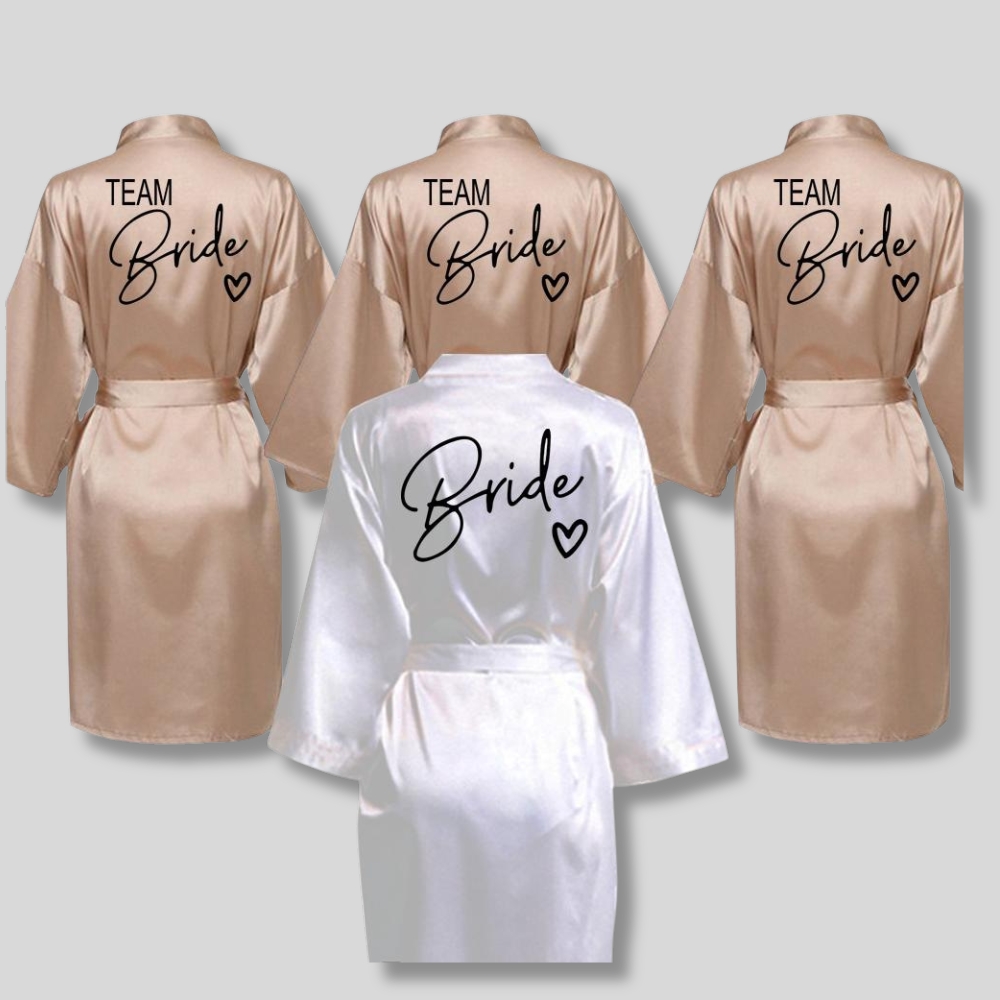 Peignoir de mariage en satin pour femme en version beige et blanche, sur fond gris.