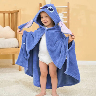 Photo d'un bébé se tenant debout portant un peignoir cape stitch bleu avec une capuche
